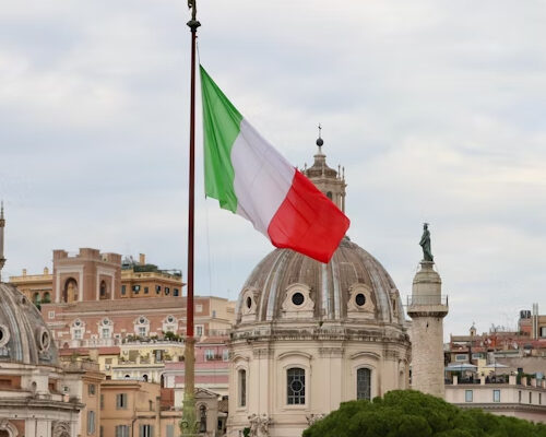 Flaga Włoch na tle rzymskiej panoramy z charakterystycznymi kopułami